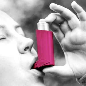 Eine Frau benutzt ein Asthmagerät.